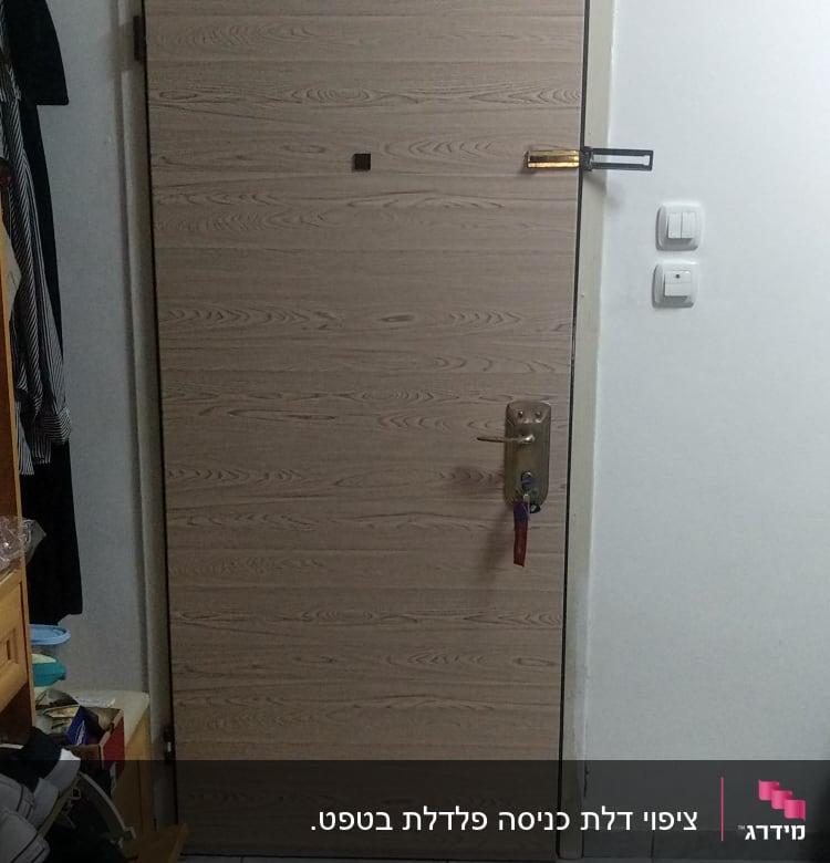 דלת עץ עם ידית מתכת ומנעול